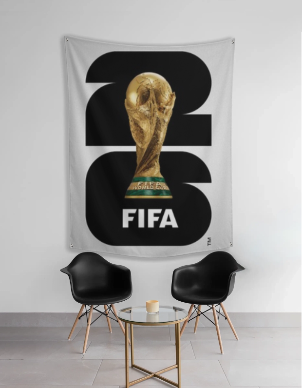 FIFA World Cup tapestry with trophy design on a wall in a room with two black chairs and a small table.