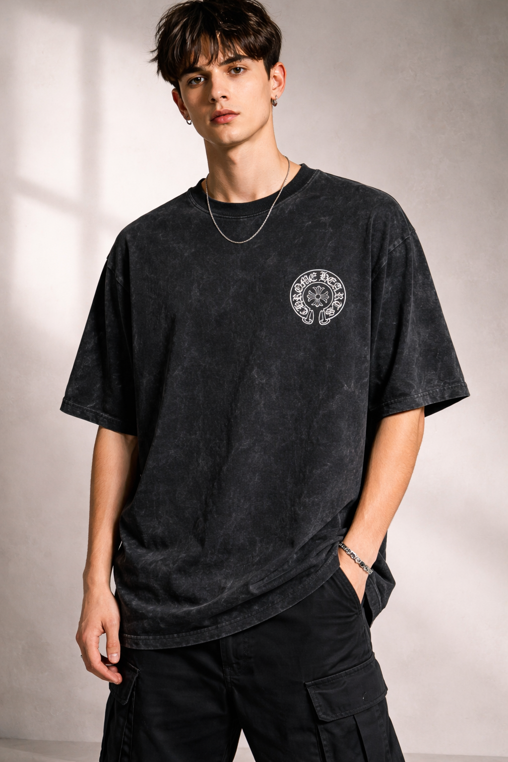 Person wearing a black t-shirt with a logo on a plain background